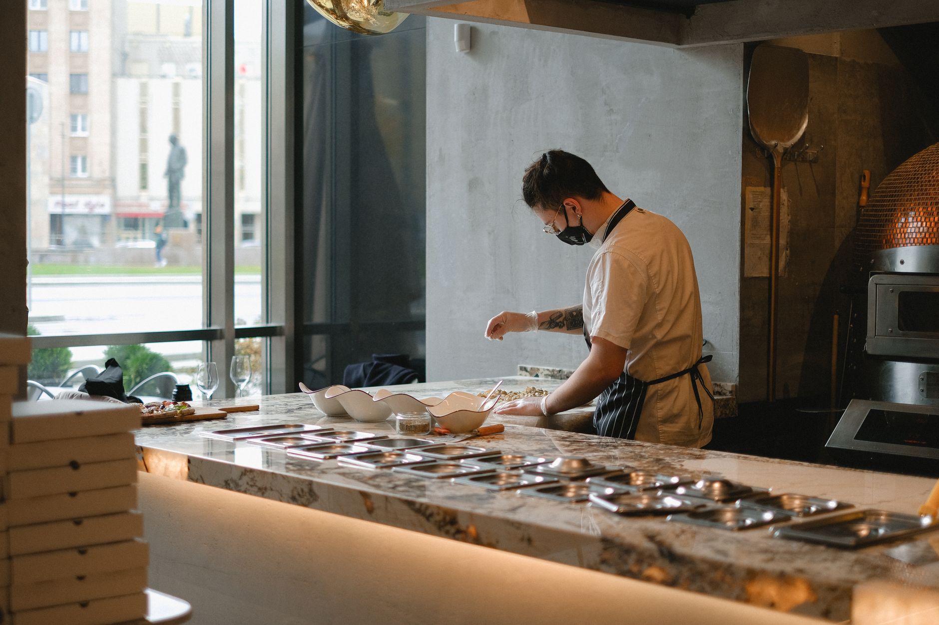 Pizzaiolo che lavora l'impasto della pizza accanto al forno a legna